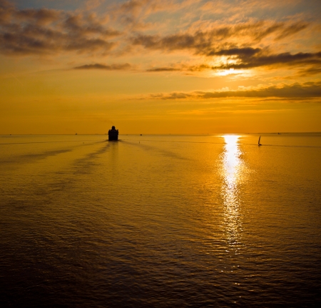 cruise liner in the sea at sunsetの写真素材