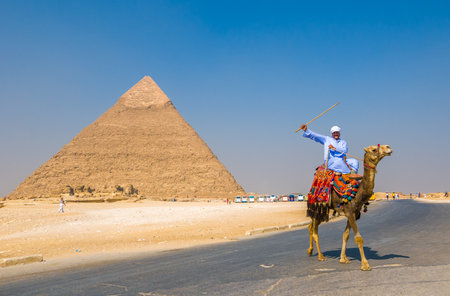 GIZA, EGYPT - September, 16, 2008: Camel rider and Pyramid of Khufu, Giza, Egyptのeditorial素材