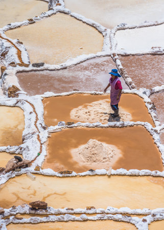 SALINAS DE MARAS, PERU - OCTOBER 12, 2015: Workers extracting salt at Salinas de Maras, man-made salt mines near Cusco, Peruのeditorial素材