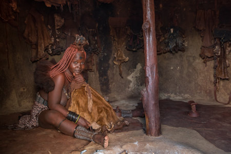 Kamanjab, Namibia - March 14, 2017: Himba woman with traditional hairstyle in Otjikandero Himba Orphanage Villageのeditorial素材
