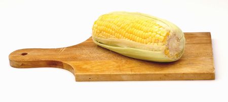 A corn on a wooden plate, isolated on white background