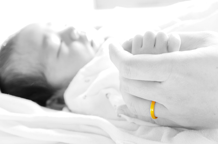 Newborn baby holding mothers hand.の写真素材