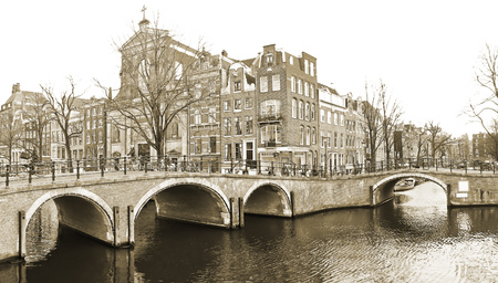 View of the canals with bridge and typical Dutch houses in Amsterdam, Netherlands.の写真素材