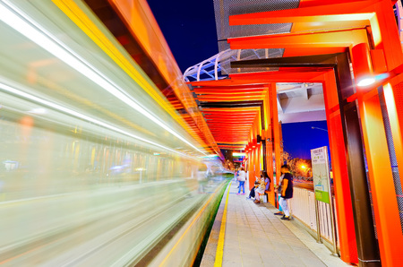 Kaohsiung, Taiwan - April 15, 2017: View of a modern tram station with a tram passing through at night in Kaohsiung, Taiwan on April 15, 2017.のeditorial素材