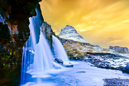 View of the Kirkjufell Mountain with Kirkjufellsfoss Waterfall at sunset in Iceland.の写真素材