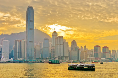 Hong Kong skyline and Victoria Harbor with ferries passing by at sunset on December 31, 2016.のeditorial素材