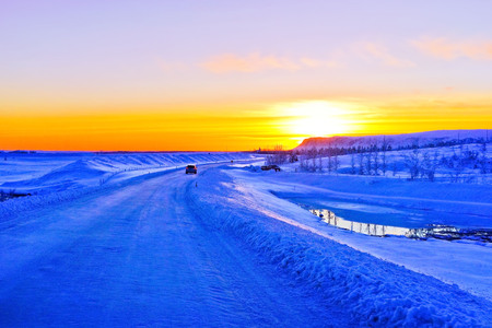 Car driving on the icy plateau at sunset in winter in Iceland.の写真素材