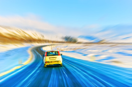Car driving on the icy road in winter in Iceland with motion effect.の写真素材