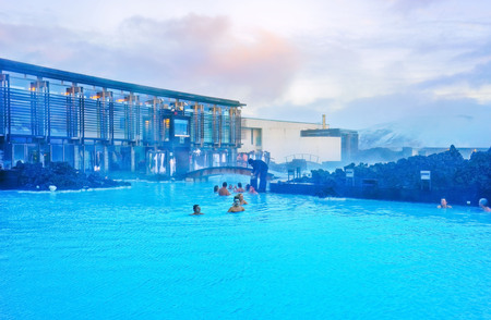 View of the Blue Lagoon pool and visitor's building at dusk with lots of tourists bathing in Blue Lagoon, Iceland on January 27, 2017.のeditorial素材
