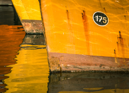 In the water, the reflection of old fishing boats moored in the port of Mar del Plata, Argentinaの写真素材