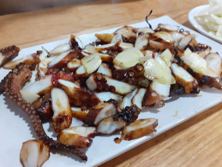 Grilled squid with garlic on white plate in thai restaurant.の写真素材