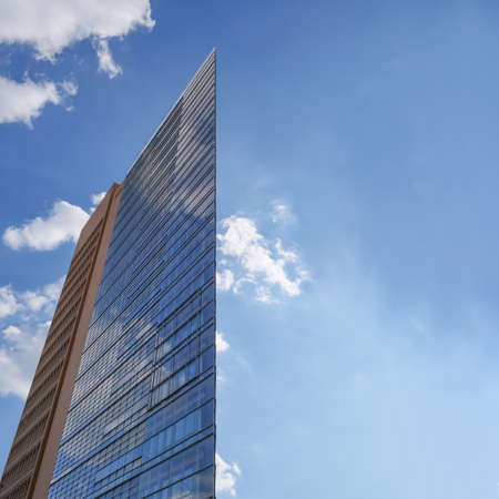 Glass building with blue sky and clouds