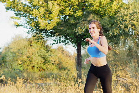 Young woman in sportswear running in the parkの写真素材