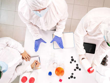 Top view of a group of scientist conducting research experiments. Concept of teamwork.