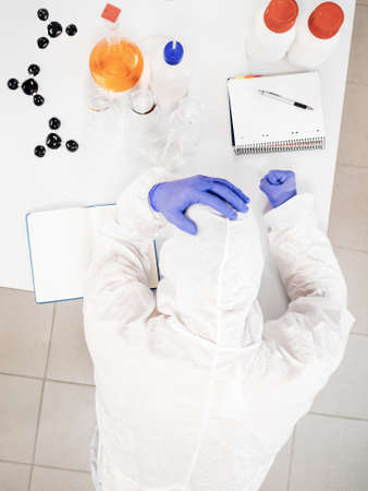 Top view of a stressed scientist on the lab table.の写真素材