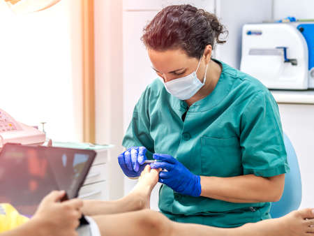 Female podiatrist doing chiropody in her podiatry clinic. Selective focusの写真素材