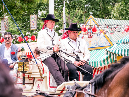 Seville, Spain - May 04, 2022 : Men in traditional costume on a horse-drawn carriage at the April Fair, Feria de Sevilla, Andalusia, Spain.のeditorial素材