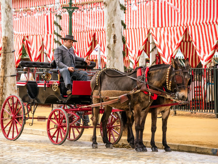 Seville, Spain - May 04, 2022 : Horse drawn carriages at the April Fair (Feria de Abril), Seville Fair (Feria de Sevilla), Andalusia, Spainのeditorial素材