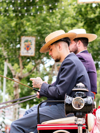 Seville, Spain - May 04, 2022 : Men in traditional costume on a horse-drawn carriage at the April Fair, Feria de Sevilla, Andalusia, Spain.のeditorial素材