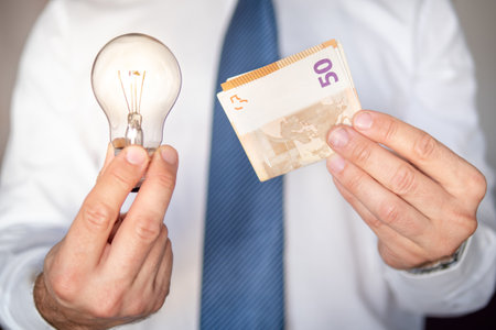 Businessman with a light bulb and money in his hands. Concept of investment and innovationの写真素材