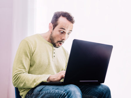 Shocked man in front of his computer. Selective focusの写真素材