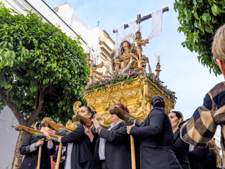 Arcos de la Frontera, Cadiz, Spain - April 7, 2023: Women Carrying Ornate Golden Float with...