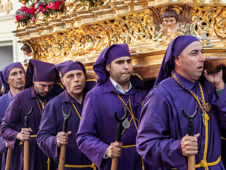 Arcos de la Frontera, Cadiz, Spain - April 7, 2023: Men Carrying Ornate Golden Float with Religious...
