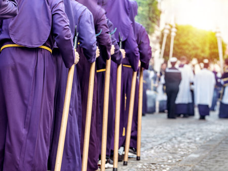 People in purple robes and yellow belts, holding wooden staffs during a procession. Selective Focus.の写真素材