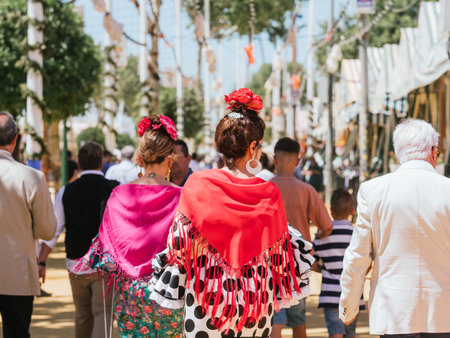 Seville, Spain - April 26, 2023 : Women in colorful flamenco dresses at the festive Seville Fair.のeditorial素材