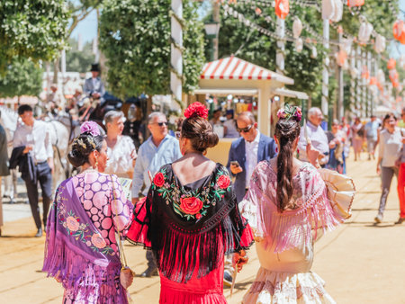 Seville, Spain - April 26, 2023 : Women in colorful flamenco dresses at the festive Seville Fair.のeditorial素材
