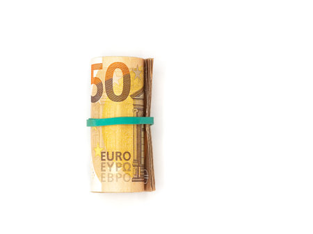 A roll of 50 Euro banknotes, bound together with a green rubber band, isolated on a white...