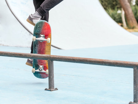 Skateboarder performing a trick on a rail at a skatepark.の写真素材