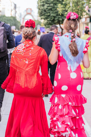 Women in colorful flamenco dresses at the festive Seville Fair.