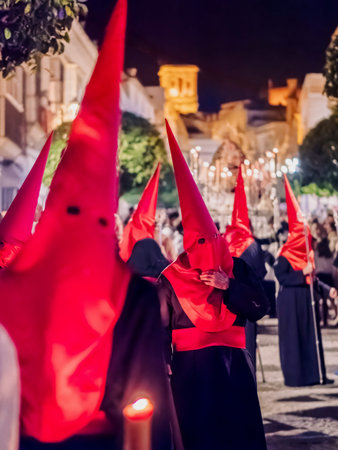 Many nazarenos with red hoods walking in processionのeditorial素材