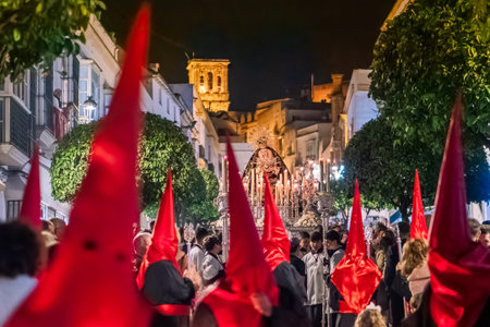 Many nazarenos with red hoods walking in processionのeditorial素材