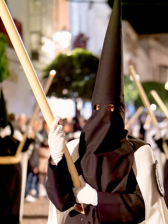 View of penitents in traditional hoods and robes during a night processionのeditorial素材