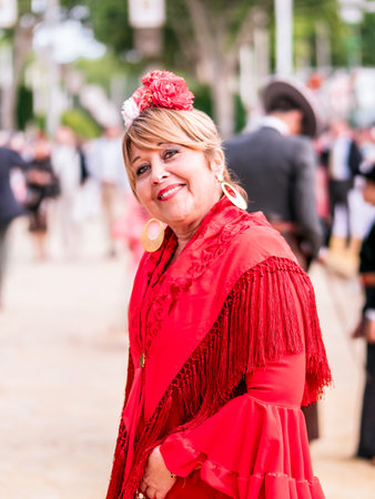 Portrait of a happy woman in a red flamenco dress at the Seville Fair