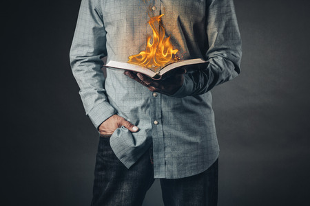 Man reading a book on fire. Reading concept.の写真素材