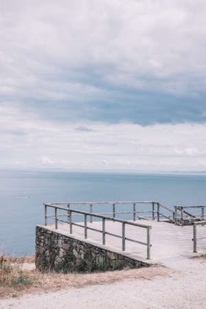Wood balcony in front of the blue sea in a sunny day in the north of Spainの写真素材