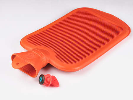 orange rubber hot water bottle is a rubber hot water bottle or bag. Warmer .isolated on white backgroundの写真素材