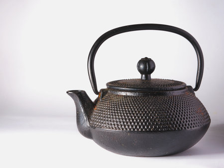 Black cast iron teapot on a white background.の写真素材