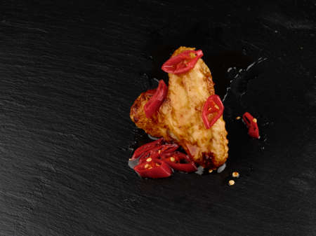 Spicy chicken wing with red chili dark backgroundの写真素材