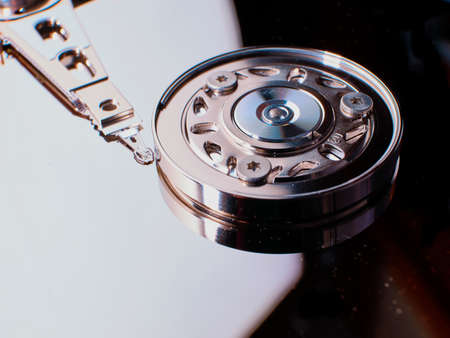 Close up of open hard disc drive (HD) with platters, spindle, actuator and read, write head, electronic hardware component for computerの写真素材
