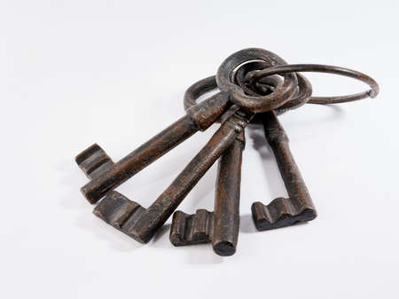 four rusty old keys isolated white backgroundの写真素材