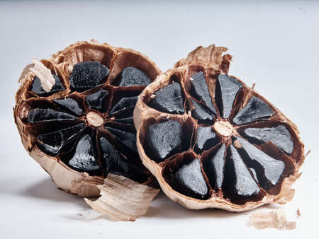 Black garlic bulbs isolated on white backgroundの写真素材