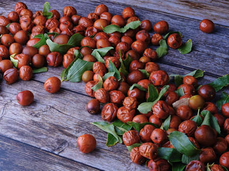 jujube fruits on wood table green leavesの写真素材