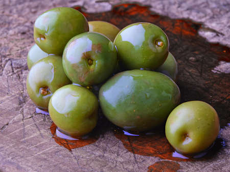 Olives green on wood table olive oilの写真素材