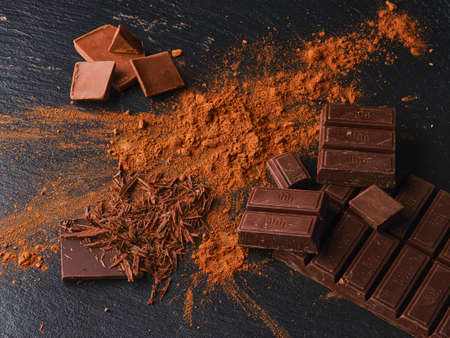 Pieces of chocolate with cocoa on dark backgroundの写真素材