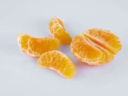 Mandarin or tangerine wedges on white backgroundの写真素材
