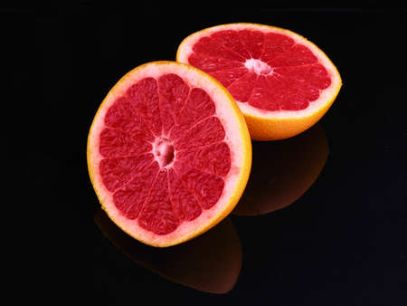 Fresh grapefruit cut in half on dark background.の写真素材